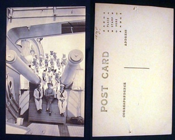 Item #15765 Real Photo Postcard of US Navy Personnel Sitting on Gun Carriage of Ship. World War II.