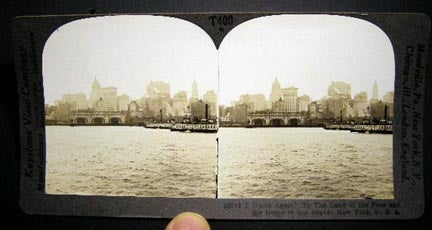 Item #19798 Stereoview Photograph Of Home Again! To the Land of the Free and Home of the Brave! New York, U.S.A. By Keystone View of New York City Skyline from the Water, Two City of New York Plant and Structures Boats in the View. New York City.